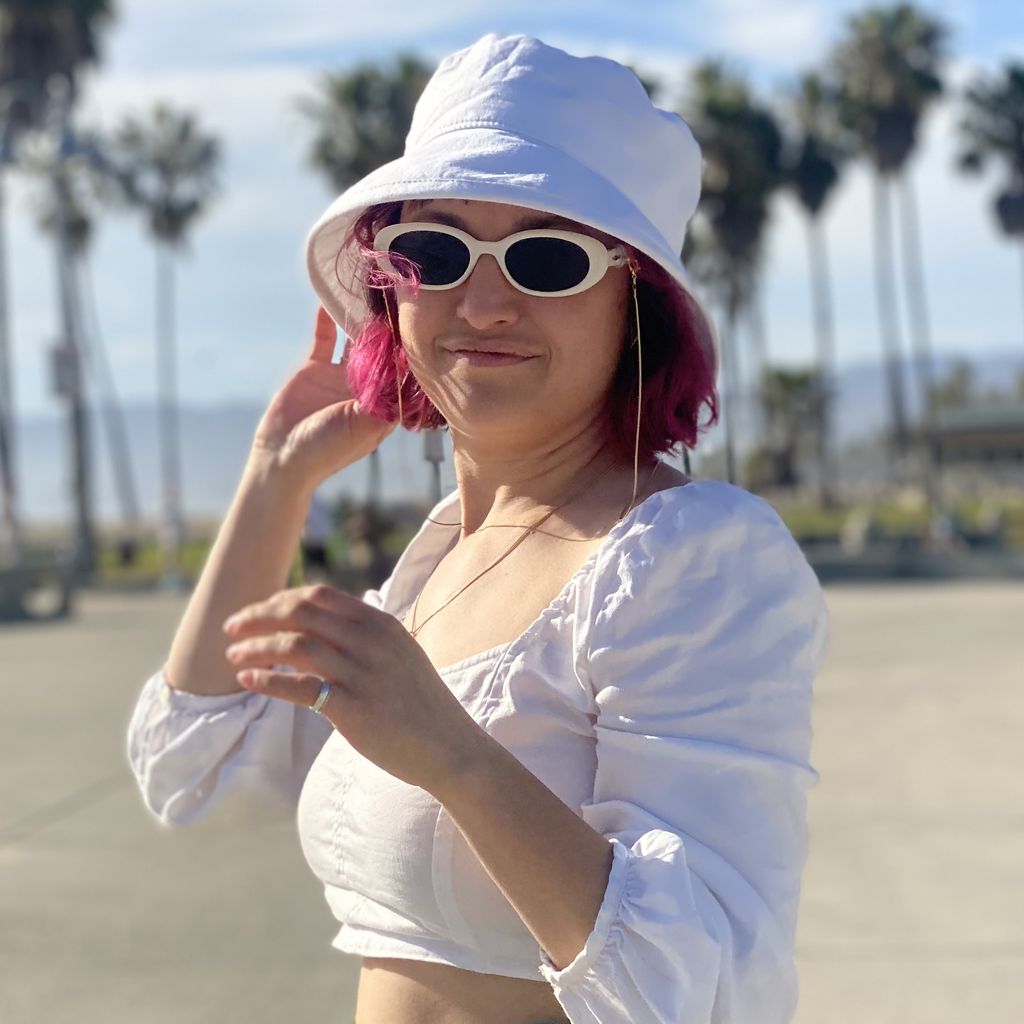 Woman wearing white linen UPF50 sun slouch hat and sunglasses at venice beach-