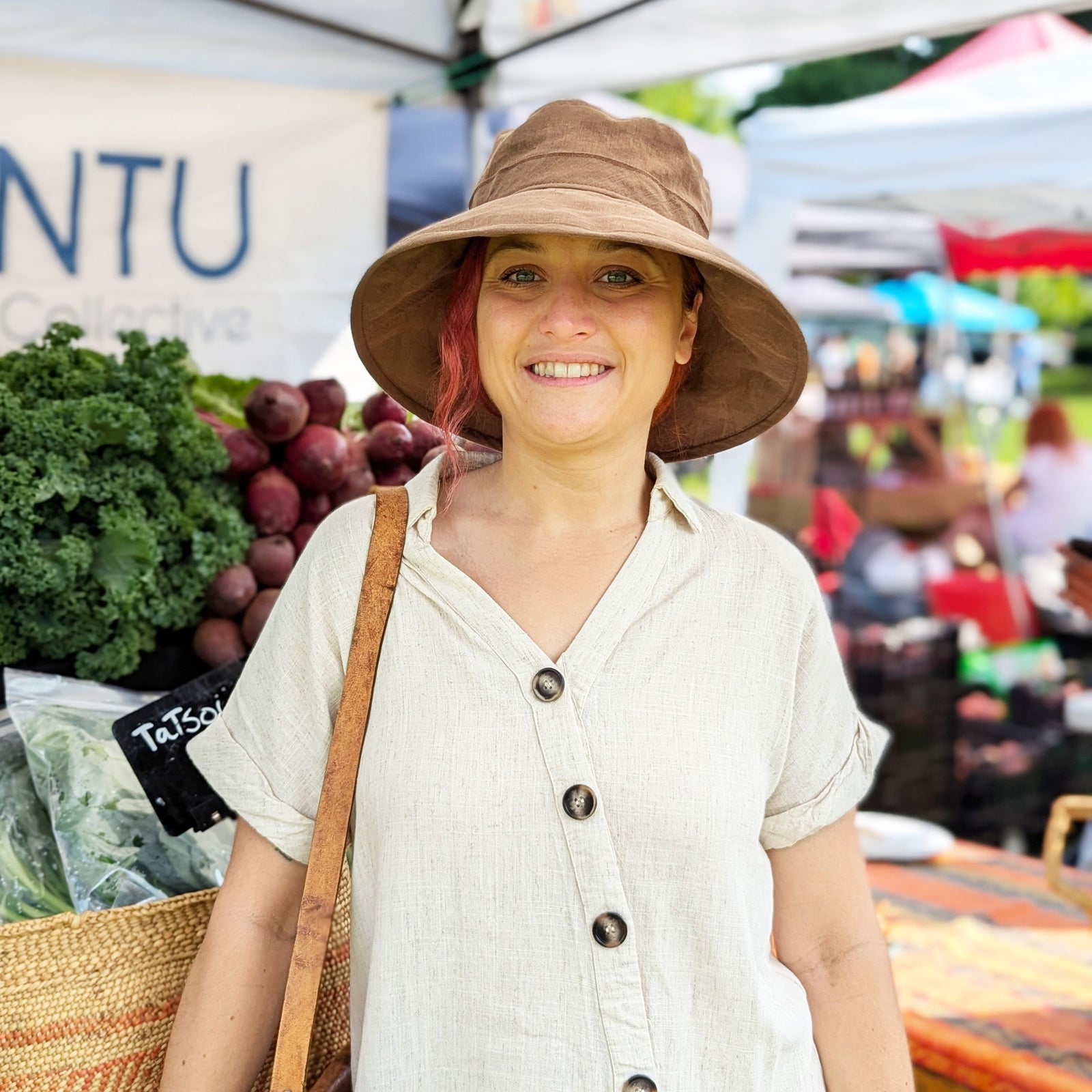 Woman in wide brim linen hat shopping at farmers market